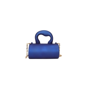 Détail du mini sac cylindrique bleu marine avec finition mate et bandoulière dorée