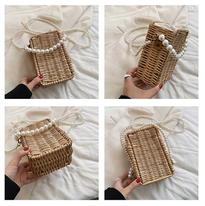 Detail view of woven straw bag with decorative pearl handle and shoulder chain
