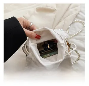 Internal view of the white canvas bucket bag showing capacity for sunglasses and cosmetics