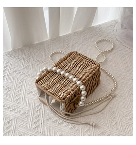 Detail of woven straw bag showing large pearl handle and soft cotton linen lining