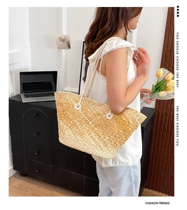 Detail of the woven texture and reinforced handles on this large beige tote bag