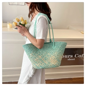 Detail of mint green woven tote bag with textured fiber pattern and slim shoulder straps