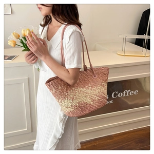 Detail of pink and beige woven tote bag showing wave texture and thin leather shoulder strap