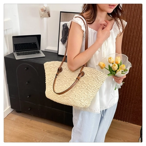 Detail of woven straw tote bag with brown leather straps and summer vacation aesthetic