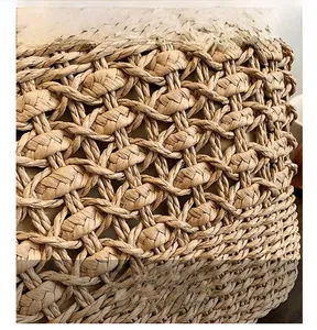 Gros plan sur le tissage ajouré en losanges d'un sac à main en paille naturelle