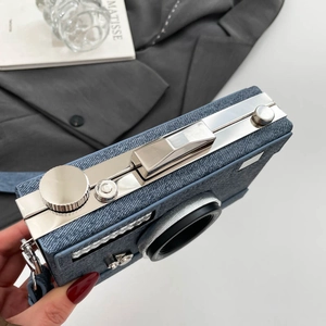 Sac bandoulière en denim forme caméra rétro avec détails métalliques et tissu bleu vintage