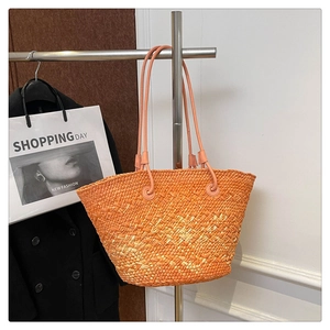 Detail of orange woven tote bag with slim faux leather straps and spacious interior