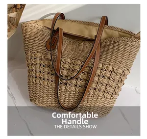 Détail des poignées en cuir marron renforcé sur le grand sac cabas en paille