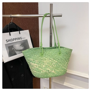 Detail of hand-woven grass green tote bag featuring natural textured fiber and slim handles