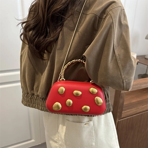 Elegant red PU leather box bag with gold pebble accents worn by model in home setting