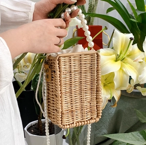 Handwoven straw square bag with pearl top handle and strap in natural summer style