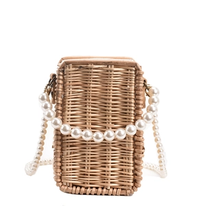 Fashionable woven straw crossbody bag with elegant pearl chain strap on white background