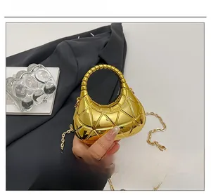 Détail du sac à main doré en forme de croissant avec texture matelassée géométrique 3D