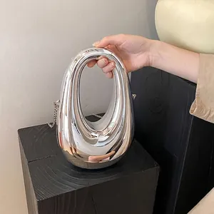 Silver metallic egg-shaped clutch bag with hollow handle and fine chain strap