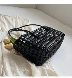 Detail of hand-woven black leather basket bag with wide strips and circular handles