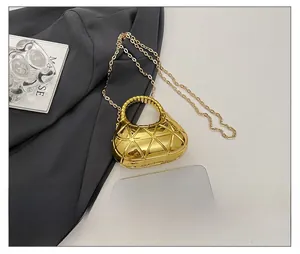 Détail du mini sac croissant doré avec texture géométrique et bandoulière en chaîne