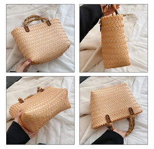 Close-up of hand-woven straw handbag with bamboo handle and metal rivet details