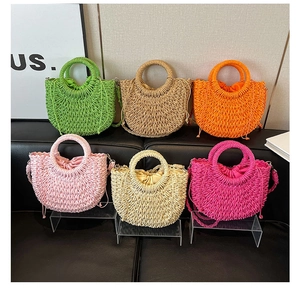 Detailed view of woven straw handbags in six vibrant colors with round top handles