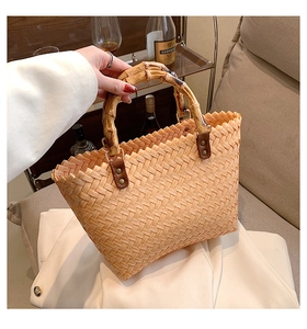Detail of the natural bamboo handle and orange woven texture on this retro handbag