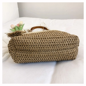 Detailed macro of handwoven straw tote with leather handle and layered base structure
