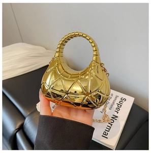 Détail du sac croissant en acrylique doré avec texture géométrique et chaîne