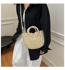 Detailed view of handmade woven straw bag with circular handle and drawstring closure