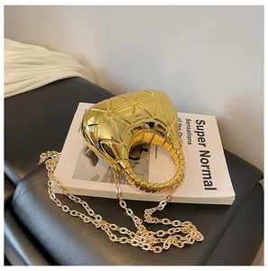 Detail der goldenen Abendtasche in Halbmondform mit geometrischem Rautenmuster