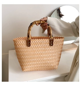 Close-up of a woven tote bag featuring a natural bamboo handle and retro bohemian texture