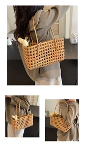 Macro detail of hand-woven hollow straw tote bag with elegant texture and slim straps