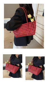 Detail of red hollow-out woven tote bag with a long shoulder strap and tulip decor