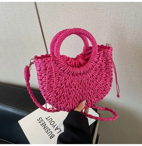 Detail of rose red straw woven handbag with drawstring inner and crossbody strap