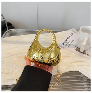 Makroaufnahme der spiegelgoldenen Acryl-Handtasche mit geometrischer Prägung