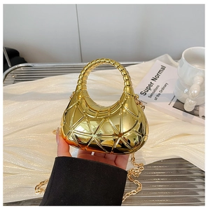 Detail einer Mini-Gold-Abendtasche mit geometrischem Dreiecksmuster und Metallgriff