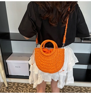 Orange hand-woven crossbody bag with drawstring liner shown on a model for beach styling
