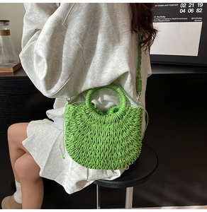 Detail of a bright green woven beach bag with round handle and drawstring interior liner
