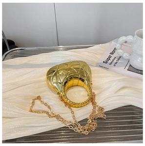Detailansicht der goldenen Acryl-Abendtasche in Halbmondform mit Kette auf Seide