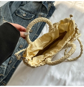 Detailed close-up of woven beige straw bag featuring a secure yellow cotton drawstring liner