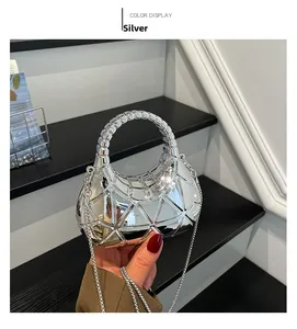 Macro detail of silver geometric acrylic box bag with reflective metallic surface finish