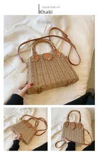 Detail of straw bag with vintage bamboo handle and brown leather strap on white fabric