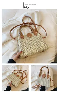 Detail of beige straw bag showing natural bamboo handle and brown leather shoulder strap