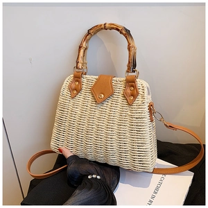 Detail of woven straw bag featuring vintage bamboo handle and brown leather closure