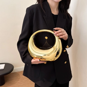 Chic golden mirror acrylic half-moon handbag held by a model in a black suit