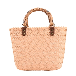 Pink woven handbag with bamboo handle and herringbone texture for beach or casual use