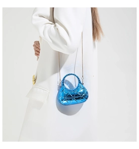 Electric blue acrylic mini bag with geometric pattern and gold chain on white suit