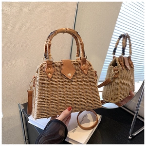 Detail of straw handbag with bamboo handle, leather trim and metallic rivets via mirror