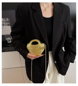Close-up of golden woven acrylic mini bag with metallic texture and sleek chain strap