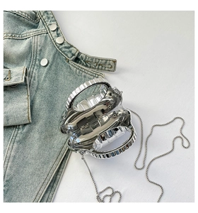 Macro shot of futuristic handcuffs-shaped acrylic clutch bag with shiny silver metal finish