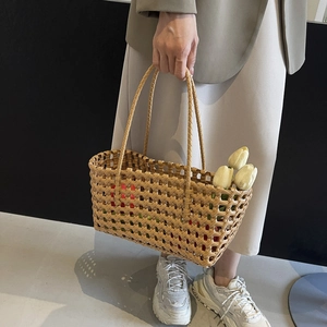 Handwoven amber brown mesh tote bag with double handles and a bouquet of tulips