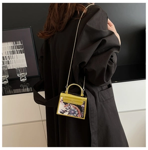 Mini acrylic clutch with colorful horse print and gold metal chain on a black coat