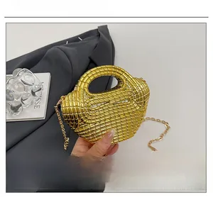 Dettaglio mini borsa dorata con trama intrecciata e tracolla a catena metallica
